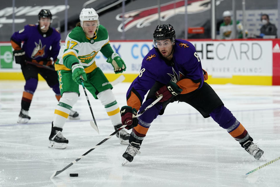 Arizona Coyotes center Nick Schmaltz (8) skates away from Minnesota Wild left wing Kirill Kaprizov (97) in the second period during an NHL hockey game, Saturday, March 6, 2021, in Glendale, Ariz. (AP Photo/Rick Scuteri)