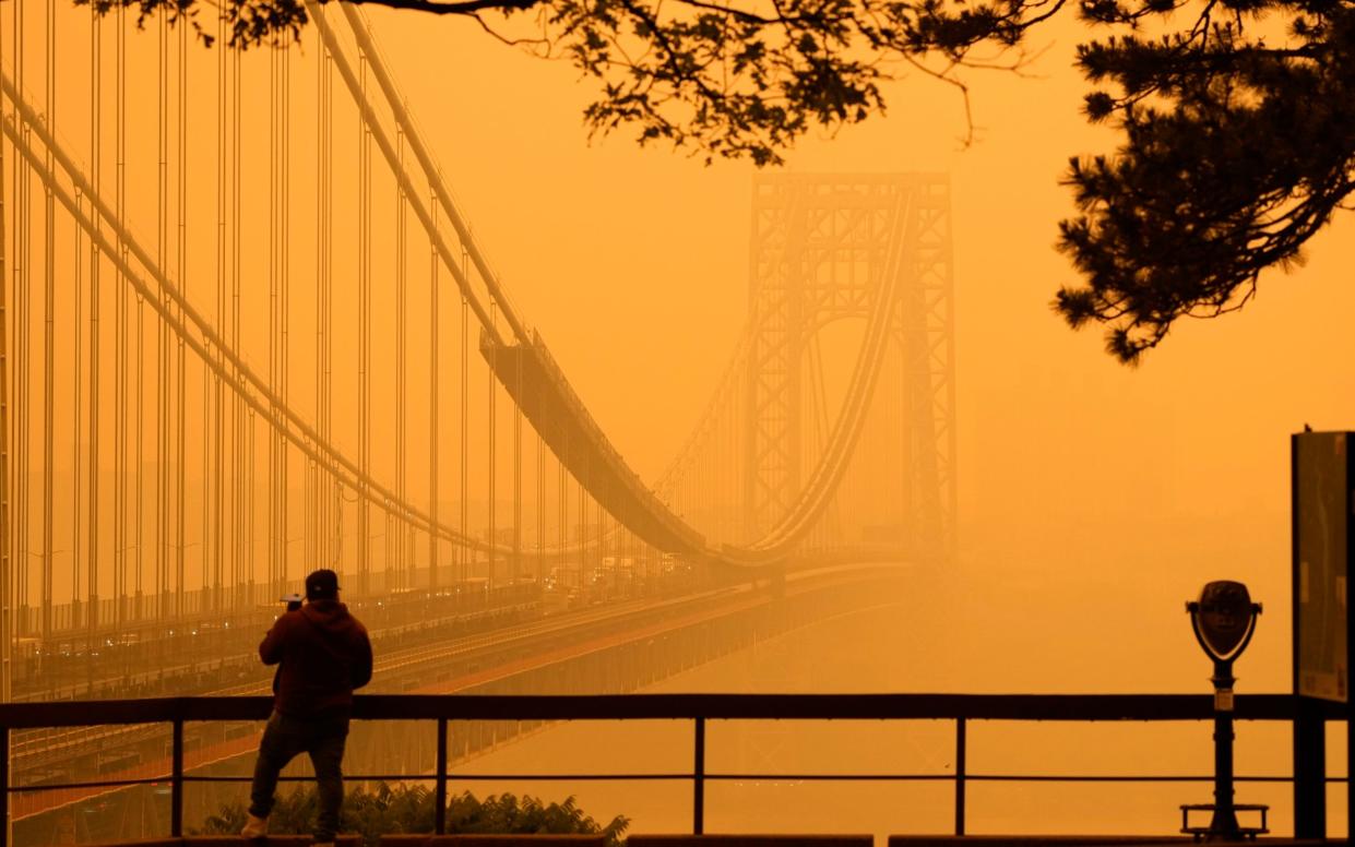 Orange clouds virtually engulfed the George Washington Bridge, connecting New Jersey and New York City - Seth Wenig/AP