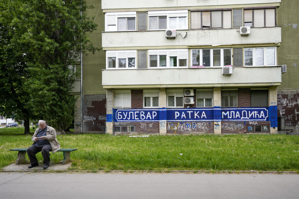 A man rests on a bench by a mural reading ''Boulevard Ratko Mladic" in Belgrade, Serbia, Tuesday, May 9, 2023. The avenue is not officially named after the Bosnian Serb general who was convicted of genocide by an international court for war crimes committed by his troops during the clashes in the Balkans in the 1990s. It carries the name of Serbia's first pro-Western Prime Minister Zoran Djindjic who was gunned down by a sniper bullet in front of his government's offices in Belgrade on March 12, 2003. (AP Photo/Darko Vojinovic)