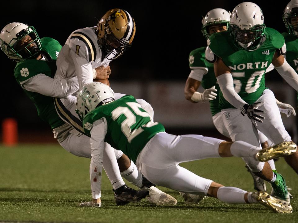 Jasper’s Charlie Kabrick (1) is tackled by North’s Jeremiah Thomas (2) and North’s Kasey Hospelhorn (25) as the Jasper Wildcats play the North Huskies at Bundrant Stadium in Evansville, Ind., Friday evening, Oct. 7, 2022. 