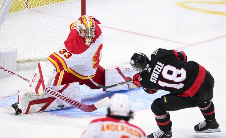 Calgary Flames goaltender David Rittich (33) makes a save on a shot from Ottawa Senators left wing Tim Stutzle (18) during second period NHL hockey action in Ottawa on Saturday, Feb. 27, 2021. (Sean Kilpatrick/The Canadian Press via AP)