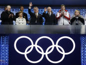 FILE - International Olympic Committee (IOC) President Thomas Bach, third from left, and Russian President Vladimir Putin, third from right, wave to spectators during the closing ceremony of the 2014 Winter Olympics, on Feb. 23, 2014, in Sochi, Russia. International Olympic Committee president Thomas Bach says Russian athletes and officials who have been banned from international sporting events because of the war in Ukraine are being protected rather than punished. (AP Photo/Darron Cummings)