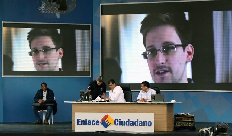 Ecuadorean President Rafael Correa speaks during his weekly programme 'Enlace Ciudadano', on June 29, 2013, with a picture of US intelligence leaker Edward Snowden, projected behind him. Correa said the United States has asked his country to reject Snowden's asylum request
