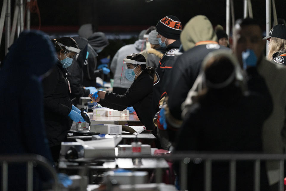 Fans take a COVID-19 test in the parking lot of the Honda Center before an NHL hockey game between the Anaheim Ducks and the Vancouver Canucks Wednesday, Dec. 29, 2021, in Anaheim, Calif. (AP Photo/Jae C. Hong)