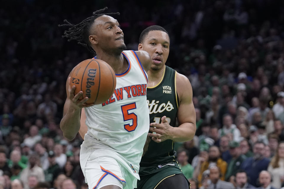 New York Knicks guard Immanuel Quickley (5) drives toward the basket as Boston Celtics forward Grant Williams (12) defends in double overtime of an NBA basketball game, Sunday, March 5, 2023, in Boston. (AP Photo/Steven Senne)