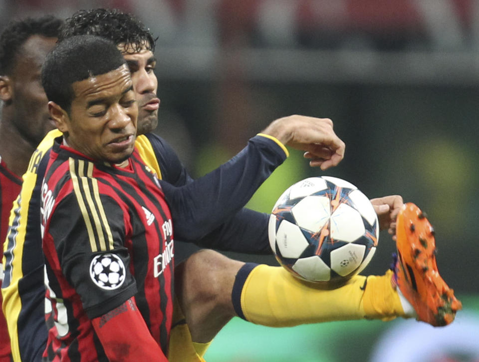 Atletico Madrid Brazilian forward Diego Costa, right, vies for the ball with AC Milan midfielder Urby Emanuelson, of the Netherlands, during a Champions League, round of 16, first leg, soccer match between AC Milan and Atletico Madrid at the San Siro stadium in Milan, Italy, Wednesday, Feb. 19, 2014. (AP Photo/Antonio Calanni)