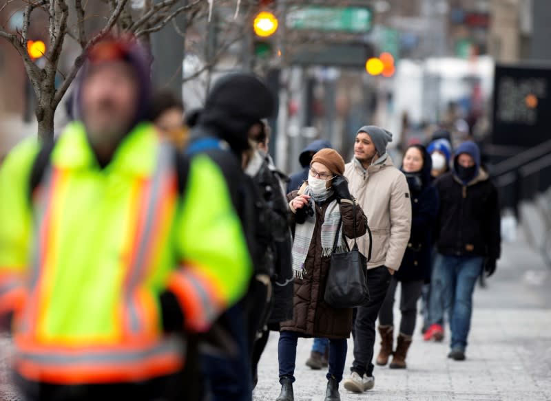 A woman adjusts her mask while she waits in line as the city's public health unit holds a walk-in clinic testing for coronavirus disease (COVID-19) in Montreal