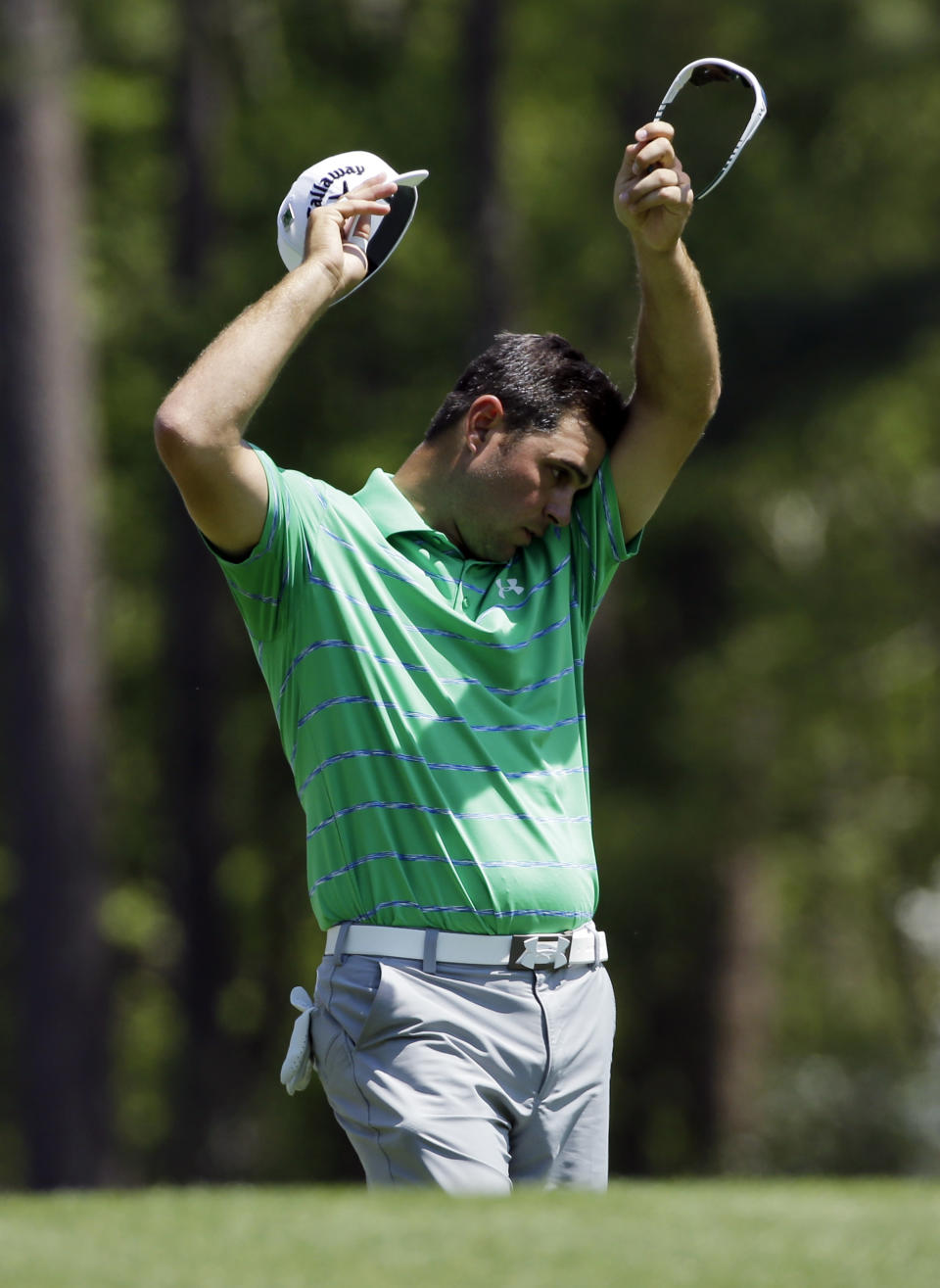Gary Woodland wipes his brow before teeing off on the12th hole landed in the water during the third round of the Masters golf tournament Saturday, April 12, 2014, in Augusta, Ga. (AP Photo/David J. Phillip)