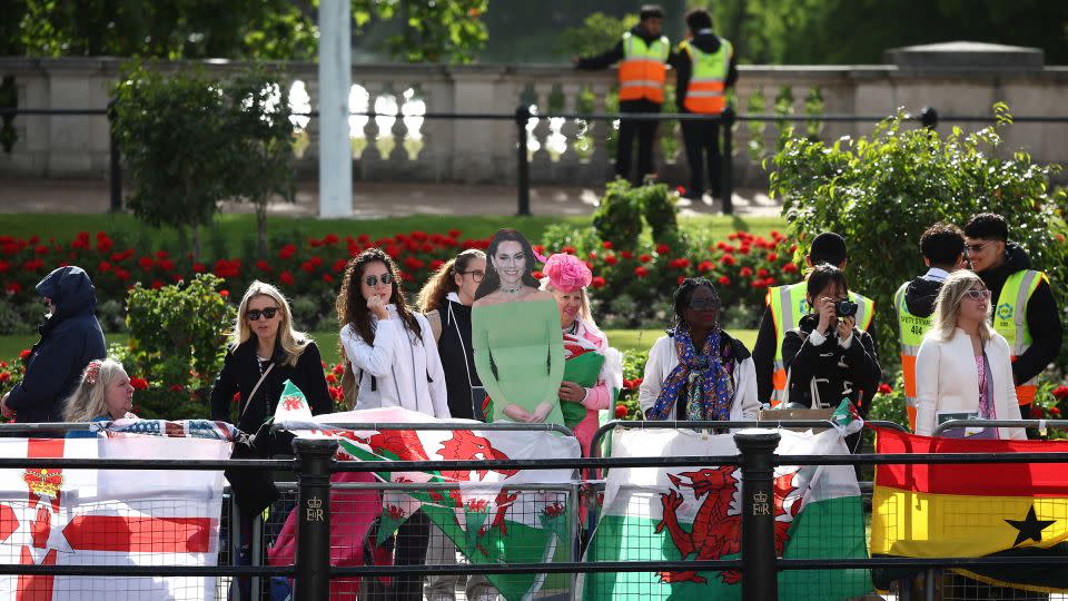 Royal fans hold a cardboard cutout of Catherine, Princess of Wales, as they wait on The Mall outside Buckingham Palace. - Henry Nicholls/AFP/Getty Images