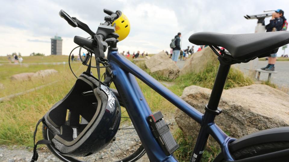 Zwei Helme hängen an einem Fahrrad, das auf dem Brocken steht.