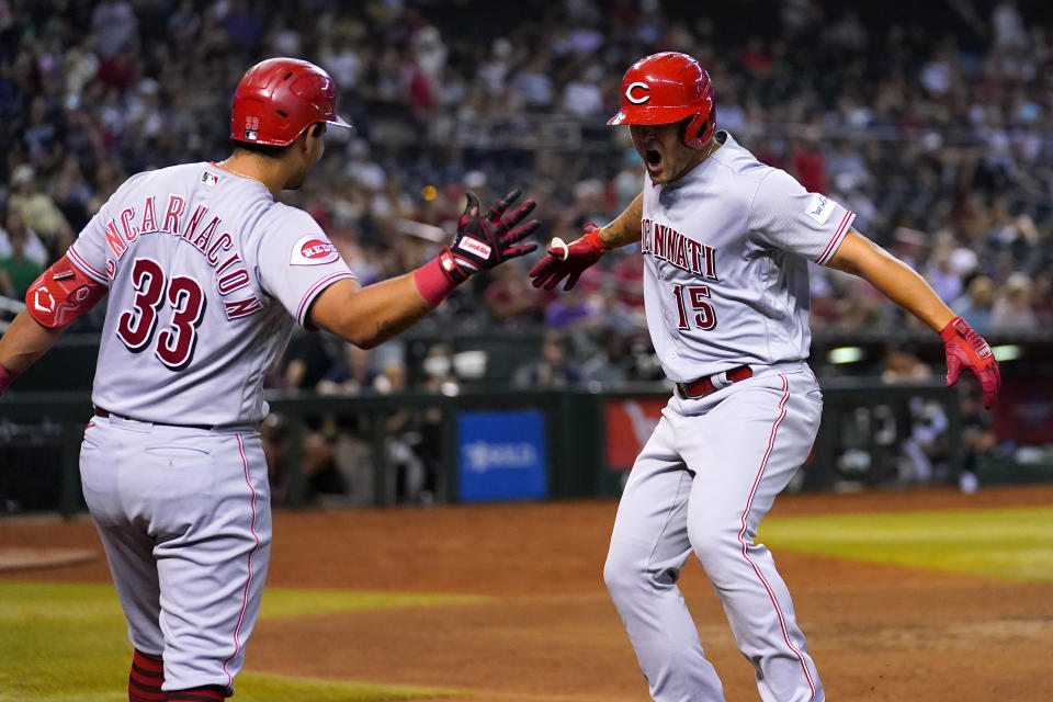 Cincinnati Reds' Nick Senzel (15) celebrates his solo home run with Christian Encarnacion-Strand (33) during the eighth inning of a baseball game against the Arizona Diamondbacks, Thursday, Aug. 24, 2023, in Phoenix. (AP Photo/Matt York)