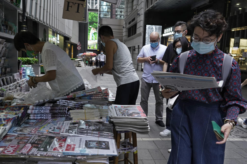 People queue up at a news stand to buy copies of Apple Daily at a downtown street in Hong Kong Tuesday, Aug. 11, 2020, as a show of support, a day after the arrest of its founder Jimmy Lai. Hong Kong authorities arrested media tycoon Jimmy Lai on Monday, broadening their enforcement of a new national security law and stoking fears of a crackdown on the semi-autonomous region's free press.(AP Photo/Vincent Yu)