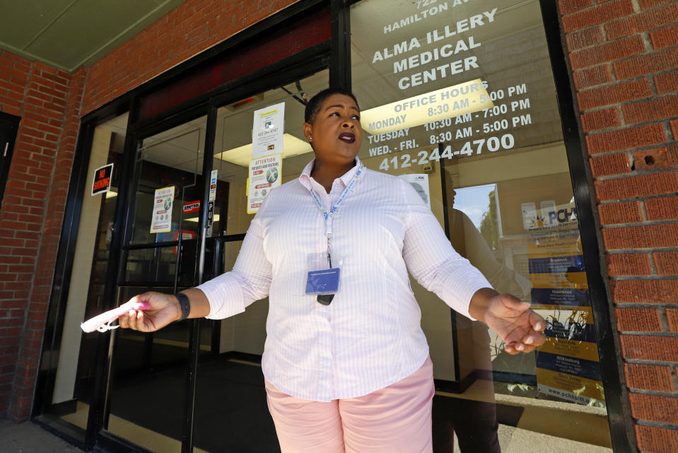 In this photo made on Monday, July 20, 2020, social worker Kiva A. Fisher-Green stands outside the Alma Illery Medical Center in the Homewood neighborhood of Pittsburgh. In March and April when Philadelphia and its surroundings became one of the nation's hot-spots for COVID-19 cases, Pittsburgh seemed at the time, to be under more control: the city racked up a fraction of the coronavirus cases as the other side of Pennsylvania. But by the beginning of July, officials in Pittsburgh's Allegheny County, began a cascading shutdown of bars, restaurants and gatherings due to an alarming spike in COVID-19 cases. (AP Photo/Gene J. Puskar)