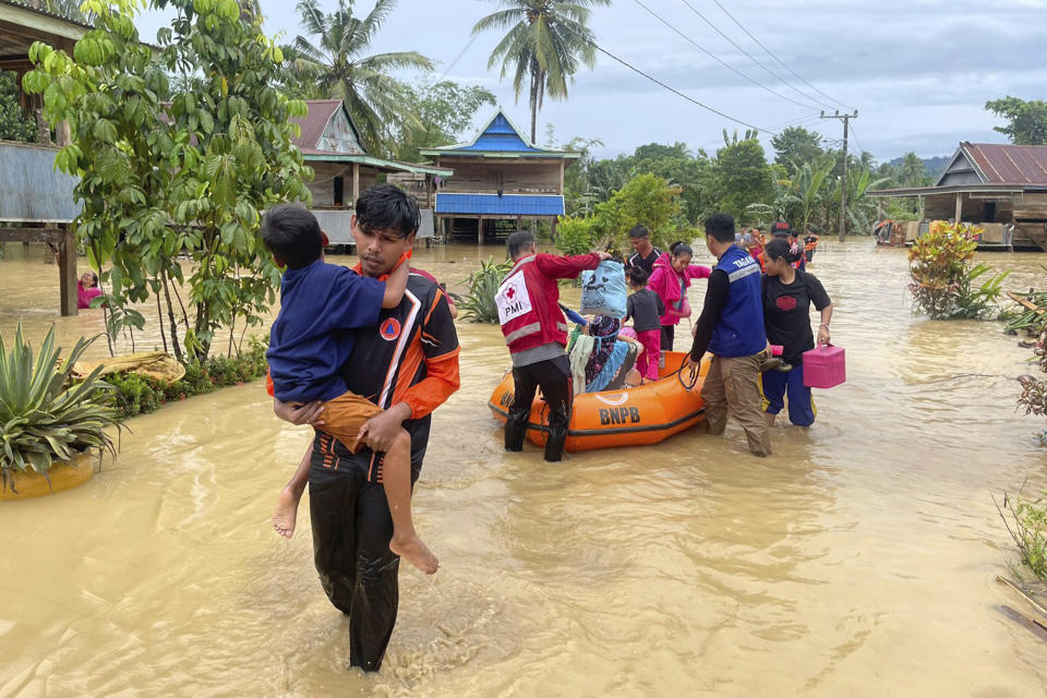 In this Friday, May 3, 2024, photo released by the Wajo Regional Disaster Management Agency (BPBD Wajo), rescuers carry people affected by a flood in Wajo, South Sulawesi, Indonesia. A flood and a landslide hit Indonesia's Sulawesi island, killing a number of people, officials said Saturday. (BPBD Wajo via AP)