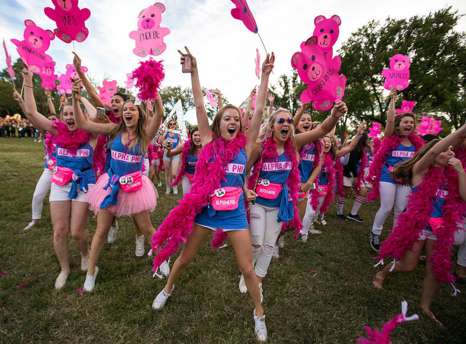 Young women in the same sorority wearing the same outfits and cheering