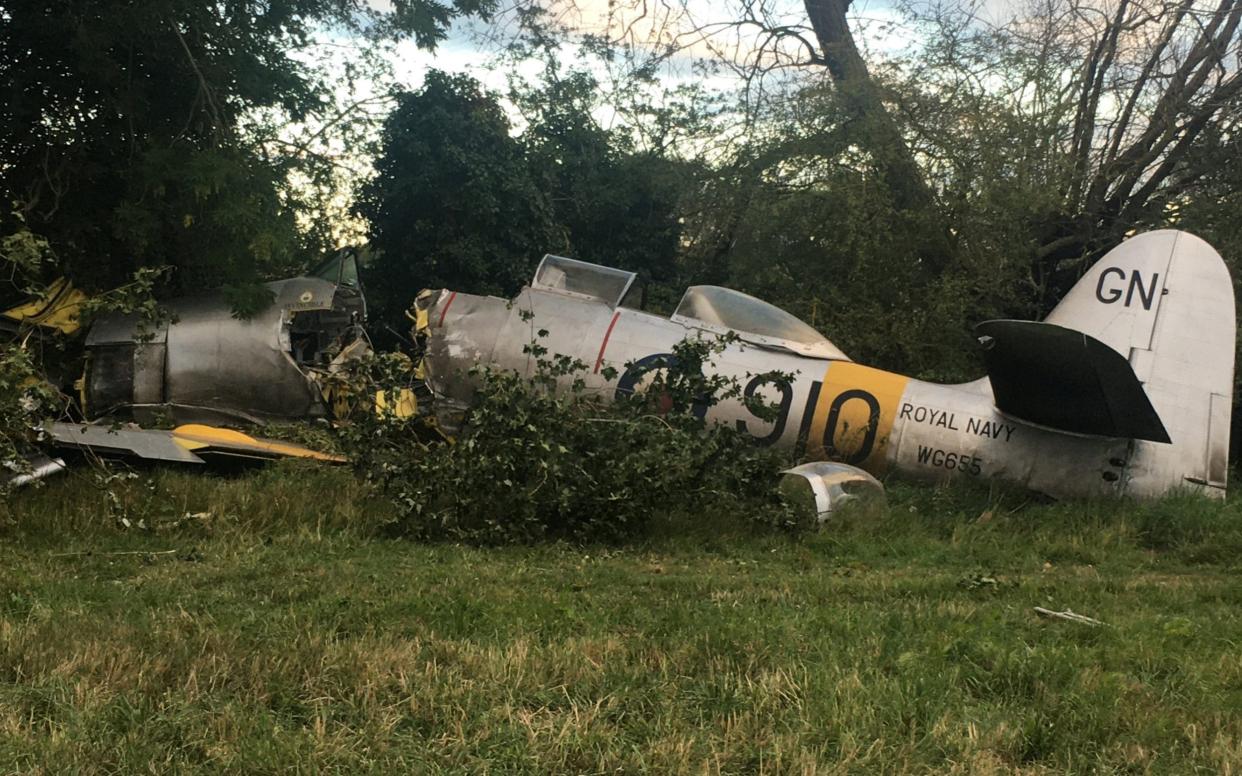 This dramatic photo shows the wreckage of a vintage British fighter plane The Hawker Sea Fury after it crashed during a routine flight in Button End near Duxford, Cambs - leaving the pilot and a passenger injured.See SWNS story SWCAcrash. This dramatic photo shows the wreckage of a vintage British fighter plane after it crashed during a routine flight - leaving the pilot and a passenger injured. The Hawker Sea Fury aircraft came down in a field at around 5.15pm yesterday evening (Tues), after having to make a forced landing, leading to the plane sustaining a fuel leak. The shocking photo shows the serious damage to the front of the plane, which appears to have been severed in two by the cockpit as it seemingly struck a tree on its way down. The pilot and a passenger both received medical attention at the scene, in Button End near Duxford, Cambs., after sustaining minor injuries in the crash. - Michael Hutchinson / SWNS.COM