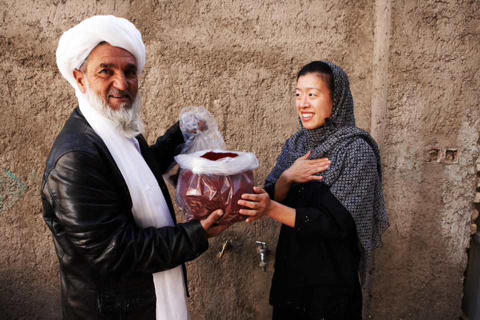 Kim Jung and an Afghan farmer show the saffron that had been farmed there for Rumi Spice.