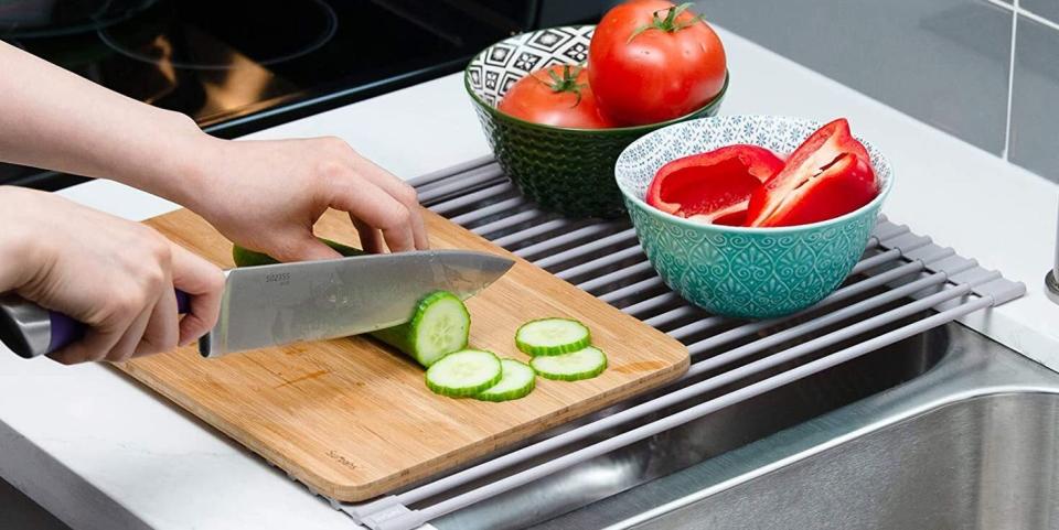 It's made with metal grates covered in soft silicone to prevent scratches and won't take up storage space.<br /><br /><strong>Promising review:</strong> "We have tried to minimize the amount of stuff taking up our kitchen countertop, so we got rid of the dish rack. I still wanted the ability to dry dishes and big pots/pans after cooking, so I got this rack. Thing is AWESOME. It is extremely versatile and rolls up neatly for storage under the sink or wherever else you'd want to store it. <strong>It repels water and makes cleaning it very simple.</strong> Gunk doesn't want to stay on it and anything that does stick to it comes right off with a light scrub and some dish soap. It doesn't smell at all and is lightweight, but very sturdy and able to hold two to three big pots and pans over the sink. You can also fold it in half if you want to access the sink but want to dry a pot or some glasses while washing." &mdash; <a href="https://amzn.to/3ecCeNc" target="_blank" rel="nofollow noopener noreferrer" data-skimlinks-tracking="5878601" data-vars-affiliate="Amazon" data-vars-href="https://www.amazon.com/gp/customer-reviews/R2MF2CRBTB96C?tag=bfmal-20&amp;ascsubtag=5878601%2C4%2C32%2Cmobile_web%2C0%2C0%2C16416120" data-vars-keywords="cleaning" data-vars-link-id="16416120" data-vars-price="" data-vars-product-id="20987515" data-vars-product-img="" data-vars-product-title="" data-vars-retailers="Amazon">Jay C.</a><br /><br /><strong>Get it from Amazon for <a href="https://amzn.to/3xaDn0P" target="_blank" rel="noopener noreferrer">$25.98+</a> (available in two sizes).</strong>