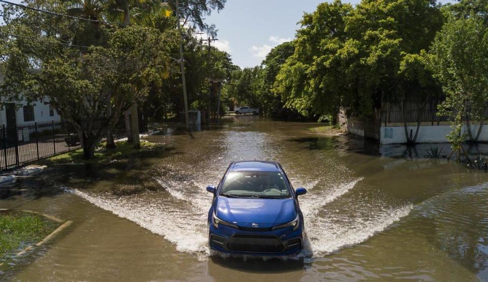 An aerial view of a vehicle making its way through a flooded street near Little River Pocket Park on Monday, Oct. 30, 2023 in Miami, Fla. Monday was the highest king tide of the year for South Florida, flooding streets, driveways and parks. MATIAS J. OCNER/mocner@miamiherald.com