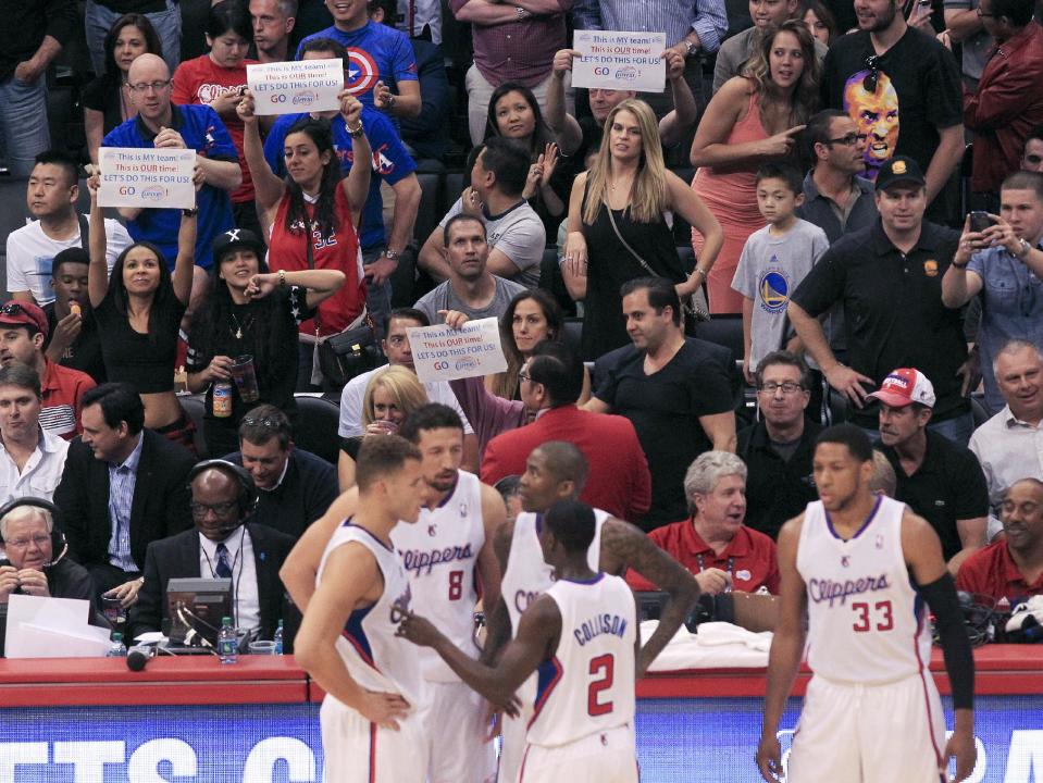 Fans hold up signs in support of the Los Angeles Clippers before Game 5 of an opening-round NBA basketball playoff series Tuesday, April 29, 2014, in Los Angeles. NBA Commissioner Adam Silver announced Tuesday that Clippers owner Donald Sterling has been banned for life by the league. (AP Photo/Ringo H.W. Chiu)