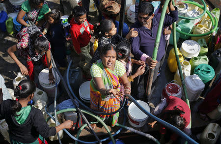 Residents fill their empty containers with water from a municipal tanker in New Delhi, India, February 22, 2016. REUTERS/Anindito Mukherjee