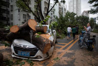 <p>A man sitting on his scooter takes photos of a car which has been damaged by a fallen tree, after Typhoon Mangkhut hit Shenzhen, Guangdong province, China on Sept. 17, 2018.<br>(Photo by Huo Jianbin, Southern Metropolis Daily via Reuters) </p>