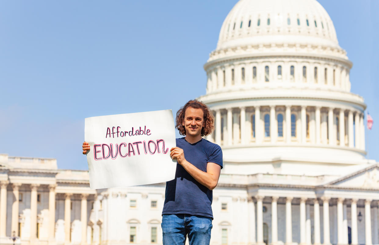 Man protest in front of the USA capitol in Washington holding sign saying asking for affordable education