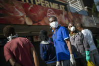 Residents of the Yeoville neighborhood of Johannesburg queue to enter a grocery store Saturday, March 28, 2020. South Africa went into a nationwide lockdown for 21 days in an effort to control the spread of the coronavirus. The COVID-19 coronavirus symptoms can include fever and cough but some suffer more severe symptoms like pneumonia and sometimes requiring hospitalization. (AP Photo/Jerome Delay)