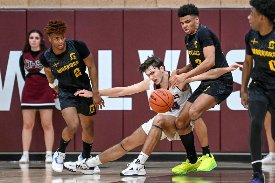 Waverly's Deonte Roberts, left, and Darrius Welch, right, pressure Okemos' Trevor Smith during the second quarter on Monday, Jan. 23, 2023, at Okemos High School.