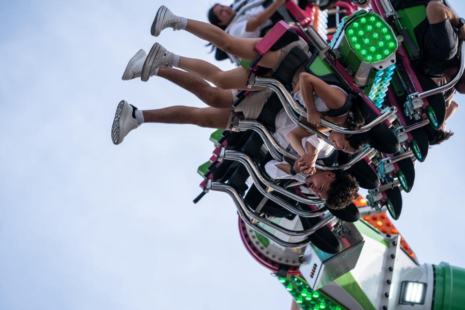 People ride rollercoasters at the Arizona State Fair in Phoenix on Sept. 22, 2023.