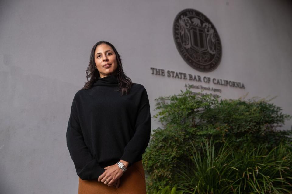 Leah Wilson stands in front of the State Bar of California seal.