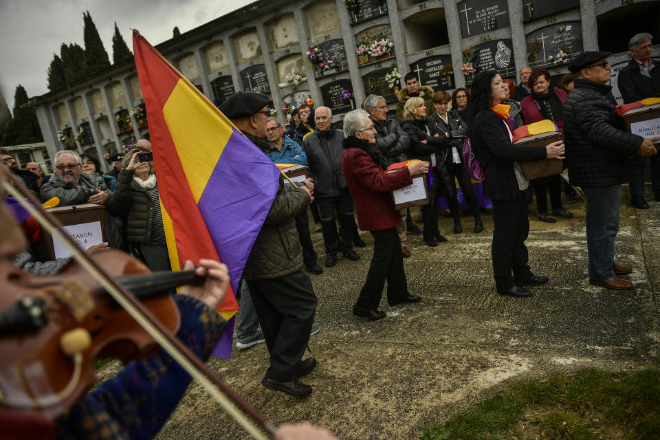 Relatives and friends, one of them with Spanish Republican flag, carry the coffins of some of the 46 coffins of unidentified people killed during the Spanish Civil War, at San Jose cemetery, Pamplona, northern Spain, Monday, April 1, 2019. Marking eight decades since the end of the Spanish Civil War, the remains of 46 unidentified victims of the conflict have been reburied in the northern city of Pamplona. More than half a million people died in the 1936-1939 war between rebel nationalist forces led by Gen. Francisco Franco and defenders of the short-lived Spanish republic. (AP Photo/Alvaro Barrientos)