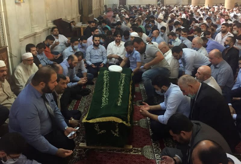 Relatives of Sunni Muslim Mufti Sheikh Mohammed Adnan Afiouni read the Quran during his funeral at Umayyad mosque in Damascus