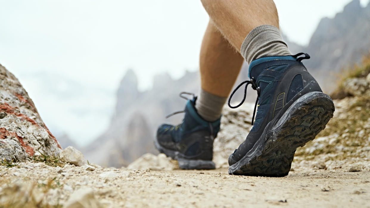  A hiker walking towards mountains. 