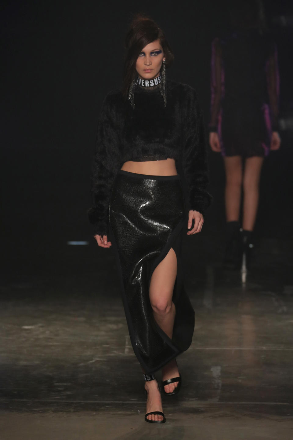 <p>Bella walked the Versus Versace runway wearing a black jumper and a high-thigh slit skirt during London Fashion Week</p>