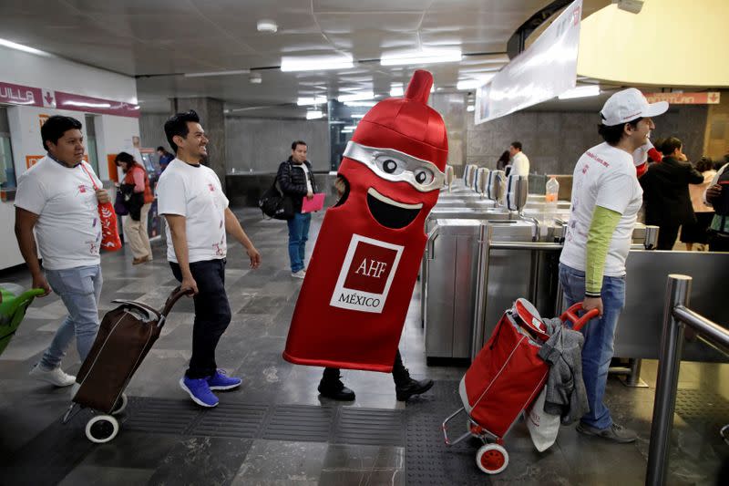 Members of an organization enter a metro station during an event organized by AIDS Healthcare Foundation for the International Condom Day, in Mexico City