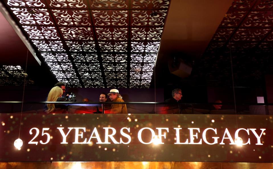 Actor Edward James Olmos sits at a table above the words "25 years of legacy."