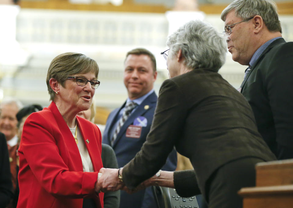 Kansas Gov. Laura Kelly, left, greets Sen. Marci Francisco, D-Lawrence, after giving her first State of the State address to lawmakers on the floor of the Kansas House on Wednesday, Jan. 16, 2019, in Topeka, Kan. (Chris Neal/The Topeka Capital-Journal via AP)