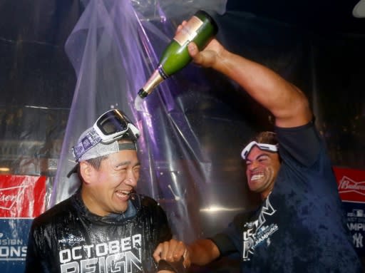 New York pitcher Masahiro Tanaka is doused with champagne by teammate Cameron Maybin after the Yankees clinched the American League East division title with a 9-1 win over the Los Angeles Angels at Yankee Stadium