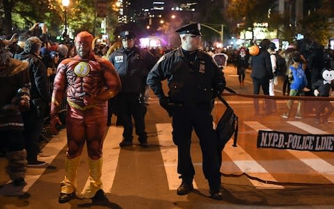 NYPD officers stand guard during the 44rd Annual Halloween Parade in New York - Credit: AFP