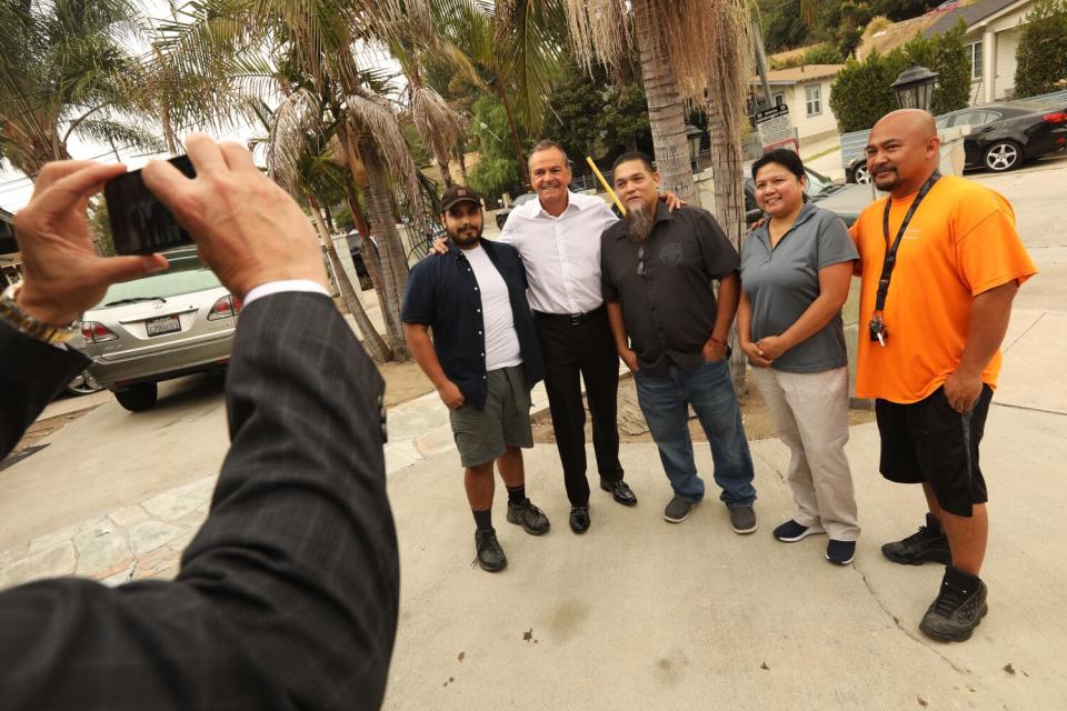 Five people stand outdoors and pose for a photo.