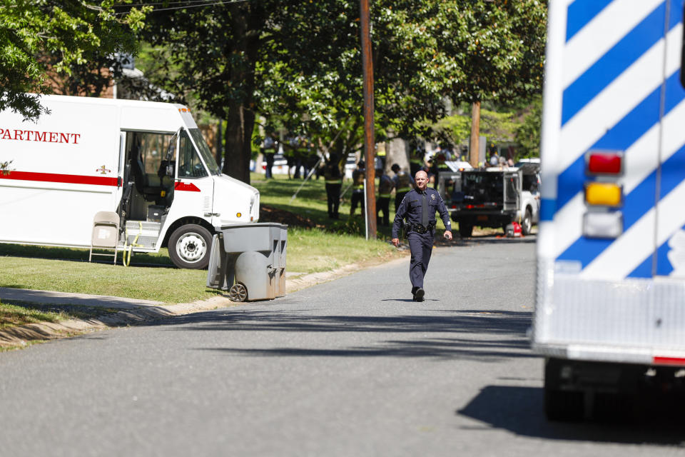 A Charlotte Mecklenburg police officer walks in the neighborhood where a shooting took place in Charlotte, N.C., Monday, April 29, 2024. The Charlotte-Mecklenburg Police Department says officers from the U.S. Marshals Task Force were carrying out an investigation Monday afternoon in a suburban neighborhood when they came under gunfire. (AP Photo/Nell Redmond)