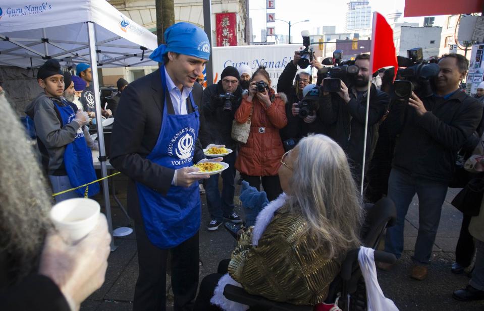 Leader of the Liberal Party of Canada MP Justin Trudeau serves a plate of food to a member in the downtown eastside neighbourhood in Vancouver, British Columbia December 18, 2013. REUTERS/Ben Nelms (CANADA - Tags: POLITICS)