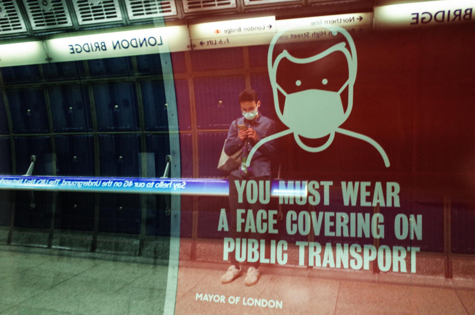 A man wearing a face mask, seen in reflection, waits for a Jubilee line service at London Bridge Station on the London Underground network in London, England, on October 15, 2020. London is to be placed under 'Tier 2' coronavirus lockdown measures from midnight on Friday, meaning 'high' alert for covid-19. Most notably the change will introduce a ban on people from different households from mixing anywhere indoors, prompting particular concern within the already badly-affected hospitality industry. (Photo by David Cliff/NurPhoto via Getty Images)