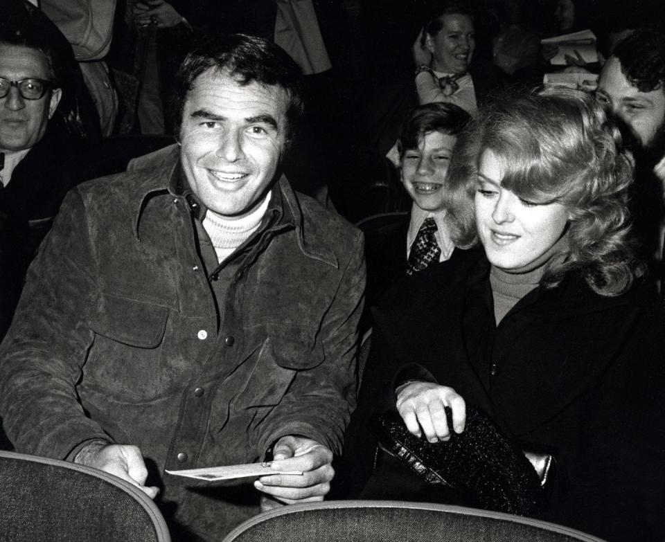 <p>Reynolds settles into his seat at a theater with his date, Bernadette Peters. The actors were there to see a performance of <em>Molly</em> on Broadway.</p>