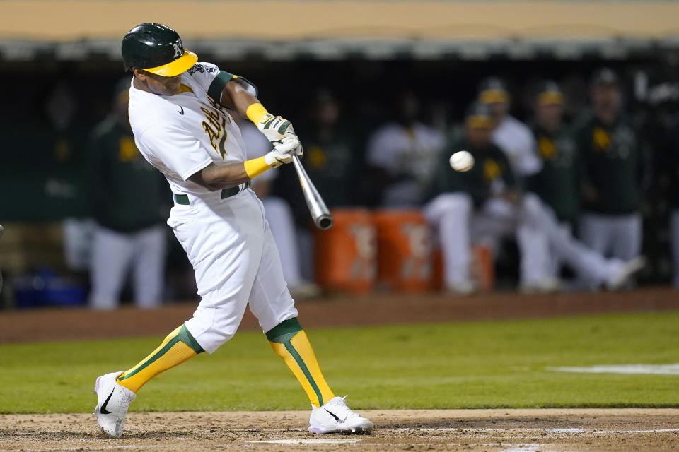 Oakland Athletics' Khris Davis hits an RBI-double against the Seattle Mariners during the third inning of a baseball game in Oakland, Calif., Monday, Sept. 20, 2021. (AP Photo/Jeff Chiu)