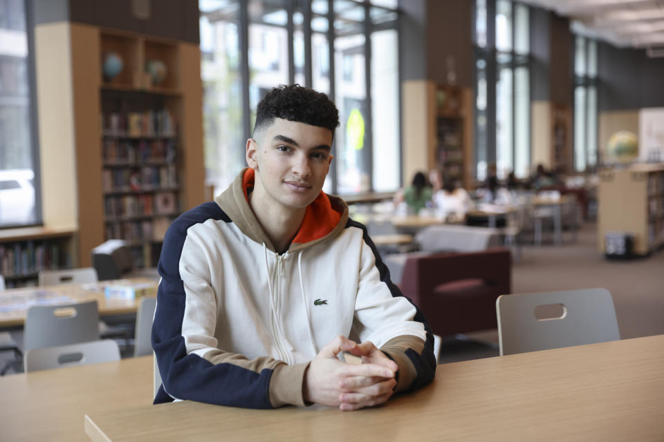 Max Decker, a senior at Lincoln High School, sits for a portrait in the school library where he often worked on writing his college essays, in Portland, Ore., Wednesday, March 20, 2024. (AP Photo/Amanda Loman)