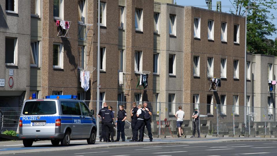 Einsatzkräfte der Polizei vor einem unter Quarantäne gestellten Wohngebäude.