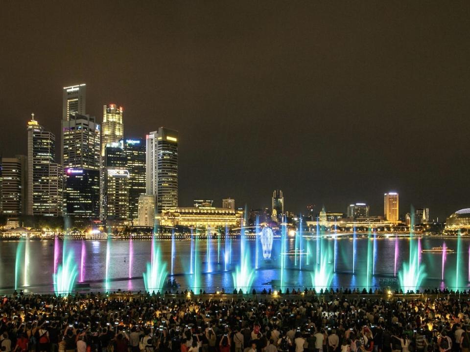 MBS' nightly light and water show with green, purple, and blue lights.