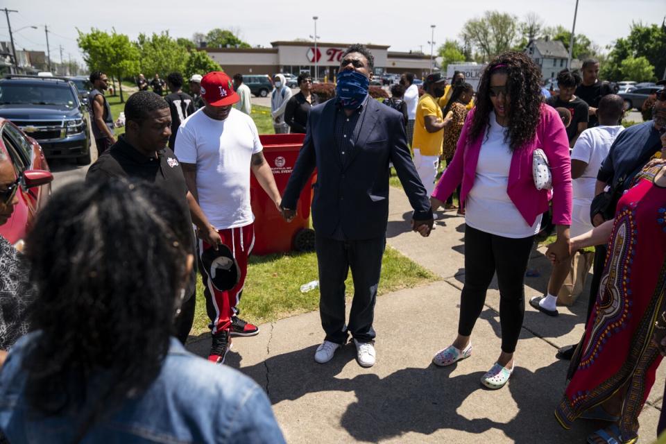 People stand in a circle holding hands